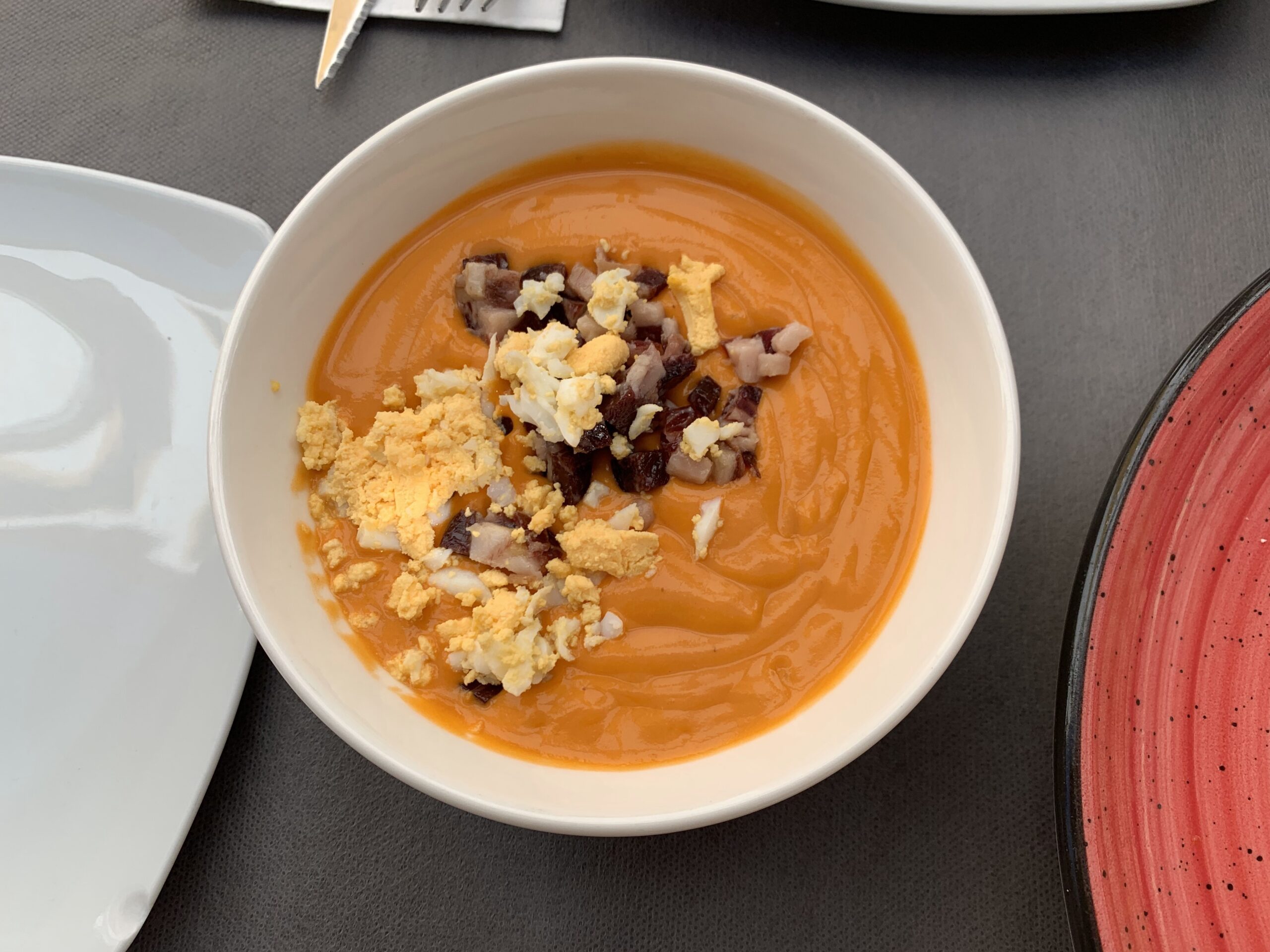 Traditional Spanish food including salmorejo on a restaurant table in Cordoba.