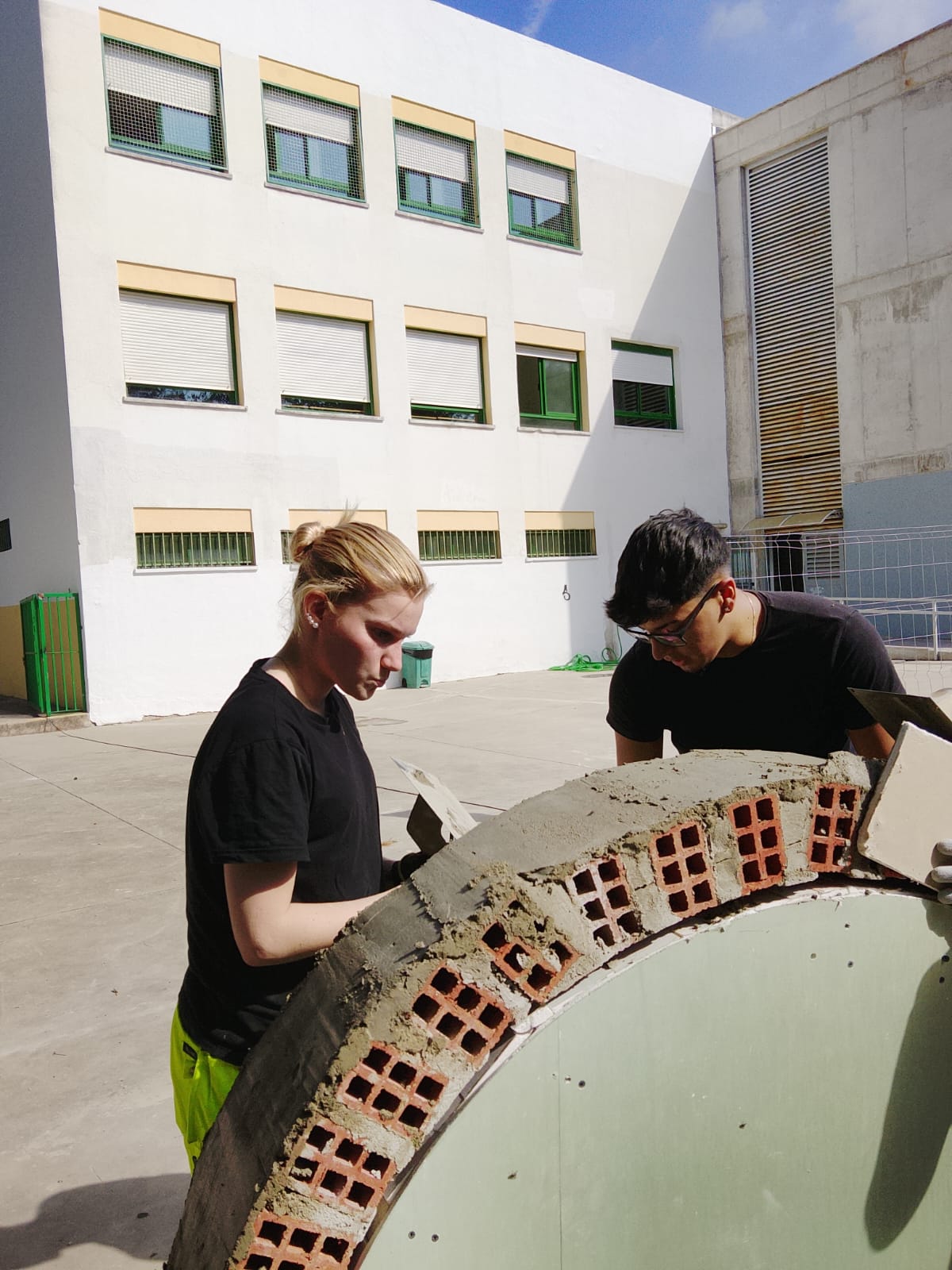 Swedish carpentry students building a brick arch with mortar during a school mobility in Córdoba